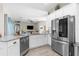 Bright kitchen boasts stainless steel appliances, white cabinets, granite countertops, and an open layout to the living area at 12333 Harris Hawk Rd, Weeki Wachee, FL 34614