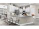 Modern kitchen features white cabinets, a granite countertop island with seating, and stainless steel appliances at 12333 Harris Hawk Rd, Weeki Wachee, FL 34614