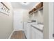 Practical laundry room with washer, dryer, sink, and ample storage shelves at 12333 Harris Hawk Rd, Weeki Wachee, FL 34614
