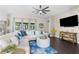 Expansive living room boasts a large sectional sofa, stylish ottoman, and scenic views through wide windows at 12333 Harris Hawk Rd, Weeki Wachee, FL 34614