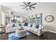 Bright living room with a white sectional, stylish decor, and an open layout leading to the kitchen at 12333 Harris Hawk Rd, Weeki Wachee, FL 34614
