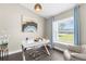 Bright office features a modern white desk, decorative light fixture and large window with serene outdoor views at 12333 Harris Hawk Rd, Weeki Wachee, FL 34614