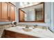 Bathroom features a marble countertop, wood cabinets, framed mirror, and updated fixtures at 12476 81St Ct, Seminole, FL 33772