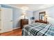A cozy bedroom features hardwood floors, blue walls, and a queen bed with a plaid comforter at 12476 81St Ct, Seminole, FL 33772