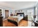 A spacious bedroom features hardwood floors, a window with blinds, and a traditional design with light blue walls at 12476 81St Ct, Seminole, FL 33772