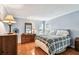 Cozy bedroom with hardwood floors, blue walls, large window, and a queen bed with a plaid comforter at 12476 81St Ct, Seminole, FL 33772