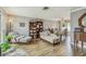 Open living room with wood-look tile flooring, natural lighting, and comfortable seating with vintage decor at 12476 81St Ct, Seminole, FL 33772