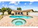 Relaxing backyard featuring a pool, spa, brick patio, and well-maintained landscaping at 12476 81St Ct, Seminole, FL 33772
