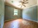 A vacant bedroom with peeling wallpaper, wood-look flooring, and a decorative ceiling fan at 12704 Lacey, New Port Richey, FL 34654