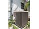A gray air conditioning unit sits on a concrete base, surrounded by shrubbery and green plants at 12704 Lacey, New Port Richey, FL 34654