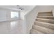 Open living room and staircase, featuring neutral tile flooring and a bright, airy feel at 1302 Twilridge Pl, Brandon, FL 33511