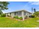Single-story home featuring a well-manicured lawn with garden and lush landscaping at 1306 Idlewood Dr # 53, Sun City Center, FL 33573