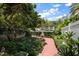 Lush garden with brick path, mature trees, and decorative statuary at 1508 S Howard Ave # A, Tampa, FL 33606