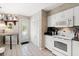 Cozy kitchen featuring white cabinets, appliances, and a convenient door leading to the outside at 1508 S Howard Ave # A, Tampa, FL 33606