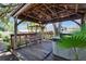 Relaxing backyard deck area featuring a hot tub, pergola, and comfortable seating at 1530 Erin Ln, Clearwater, FL 33755