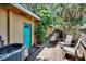 Charming backyard patio area with a bright teal door, perfect for outdoor enjoyment at 1530 Erin Ln, Clearwater, FL 33755
