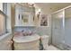 Bathroom with ornate vanity, shell-themed tile accents and a glass enclosed shower at 1530 Erin Ln, Clearwater, FL 33755
