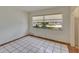 Bedroom featuring tile floors and a window with decorative shades at 1530 Erin Ln, Clearwater, FL 33755