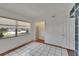 Bedroom features neutral walls, tile floors, a window, and access to a hallway at 1530 Erin Ln, Clearwater, FL 33755