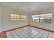 Bright bedroom featuring tile flooring, neutral walls and windows with decorative shades at 1530 Erin Ln, Clearwater, FL 33755