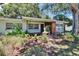 Charming home featuring lush landscaping, quaint fountain, and a delightful bridge walkway at 1530 Erin Ln, Clearwater, FL 33755