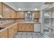 Well-lit kitchen boasting wooden cabinetry, unique patterned flooring, and a double sink at 1530 Erin Ln, Clearwater, FL 33755