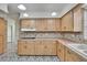 Bright kitchen featuring wooden cabinets, patterned tile flooring, and a smooth cooktop at 1530 Erin Ln, Clearwater, FL 33755