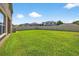 A spacious backyard features lush green grass, complemented by a well-maintained white fence and mature landscaping at 19028 Narimore Dr, Land O Lakes, FL 34638