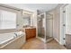 Bathroom with large tub, glass shower, and wood cabinets at 19028 Narimore Dr, Land O Lakes, FL 34638