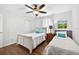 Bright bedroom with two beds, ceiling fan, and wood-look flooring at 19028 Narimore Dr, Land O Lakes, FL 34638