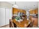 Dining area with access to kitchen, wooden table, and view of kitchen features at 19028 Narimore Dr, Land O Lakes, FL 34638