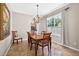 Inviting dining area features a wooden table, chandelier, and a sunlit window with elegant draperies at 19028 Narimore Dr, Land O Lakes, FL 34638