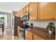 Galley-style kitchen featuring stainless steel appliances, wood cabinets, and tiled flooring at 19028 Narimore Dr, Land O Lakes, FL 34638