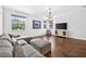 Spacious living room with wood floors, natural lighting, and a gray couch and ottomans at 19028 Narimore Dr, Land O Lakes, FL 34638