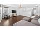 Living room with wood floors, TV and cabinet, gray chair and natural lighting from the windows at 19028 Narimore Dr, Land O Lakes, FL 34638
