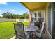 A covered patio features a table and chairs, providing an ideal outdoor dining and entertaining area at 19028 Narimore Dr, Land O Lakes, FL 34638