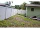 The backyard has grass, a white privacy fence, and a few chairs and accessories, offering a functional outdoor area at 2058 Dodge St, Clearwater, FL 33760