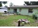 A backyard with grass, patio set, grill, and a fire pit area for outdoor enjoyment and entertainment at 2058 Dodge St, Clearwater, FL 33760