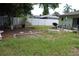 Backyard with grass, a covered patio area, a privacy fence, and some foliage providing a pleasant outdoor space at 2058 Dodge St, Clearwater, FL 33760