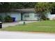 A single Gathering home with a well-maintained lawn, mature trees, and a paved driveway leading to the garage at 2058 Dodge St, Clearwater, FL 33760