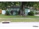 This house has a lush front yard with grass, mature trees, and bushes adding to its curb appeal at 2058 Dodge St, Clearwater, FL 33760