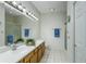 Well-lit bathroom with dual sinks, wood cabinets, and a shower, offering convenience and style at 21248 Diamonte Dr, Land O Lakes, FL 34637