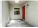 Inviting front porch featuring unique stone flooring and a vibrant orange door at 21248 Diamonte Dr, Land O Lakes, FL 34637