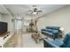 Open-concept living room with tile flooring, ceiling fan, and view of dining area and kitchen at 21248 Diamonte Dr, Land O Lakes, FL 34637