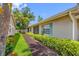 A view of the building's exterior shows the lawn, mulch walkway, and light-blue window shutters at 2131 Ridge S Rd # 19, Largo, FL 33778