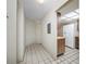 Hallway with white walls, tile floors, and access to the kitchen, offering a view of appliances and cabinets at 2131 Ridge S Rd # 19, Largo, FL 33778