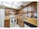 Cozy kitchen equipped with wood cabinets, white appliances, and a stainless steel sink with a window view at 2131 Ridge S Rd # 19, Largo, FL 33778