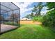 A well-landscaped backyard with lush greenery and a glimpse of the screened pool area, perfect for relaxation at 2174 Kent Ave, Clearwater, FL 33764