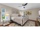 Cozy bedroom featuring a stylish wrought iron bed and warm, inviting decor and updated ceiling fan at 2174 Kent Ave, Clearwater, FL 33764