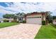 Charming home with a well-manicured lawn and a brick driveway leading to a two-car garage at 2174 Kent Ave, Clearwater, FL 33764